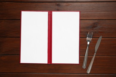 Hardcover notebook with blank sheets for menu design and cutlery on wooden table, flat lay