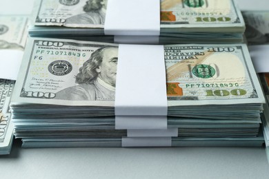 Photo of Bundles of dollar banknotes on light grey background, closeup