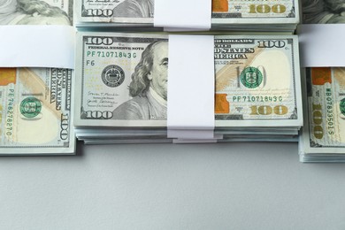 Photo of Bundles of dollar banknotes on light grey background, above view