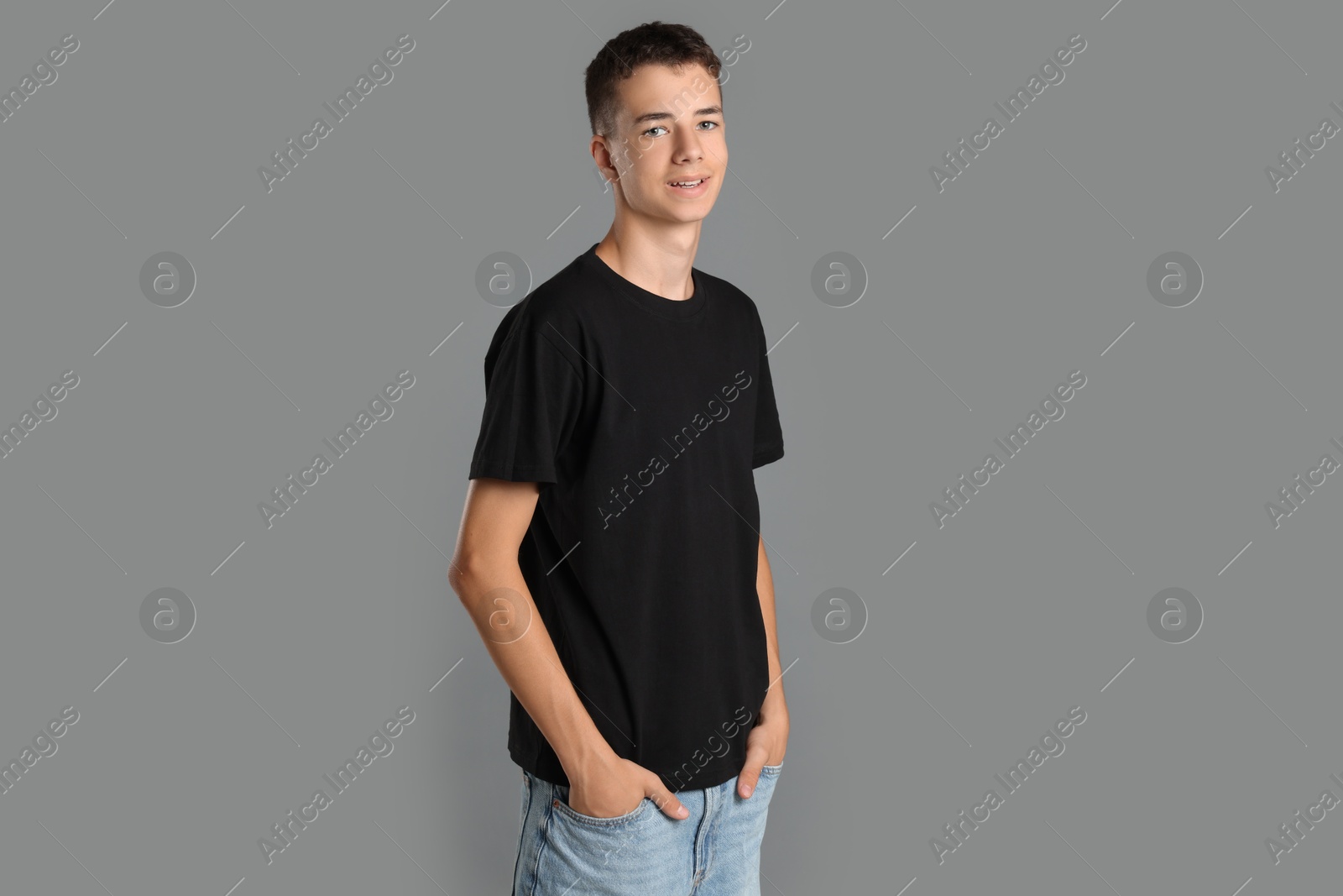 Photo of Teenage boy wearing black t-shirt on grey background