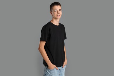 Photo of Teenage boy wearing black t-shirt on grey background