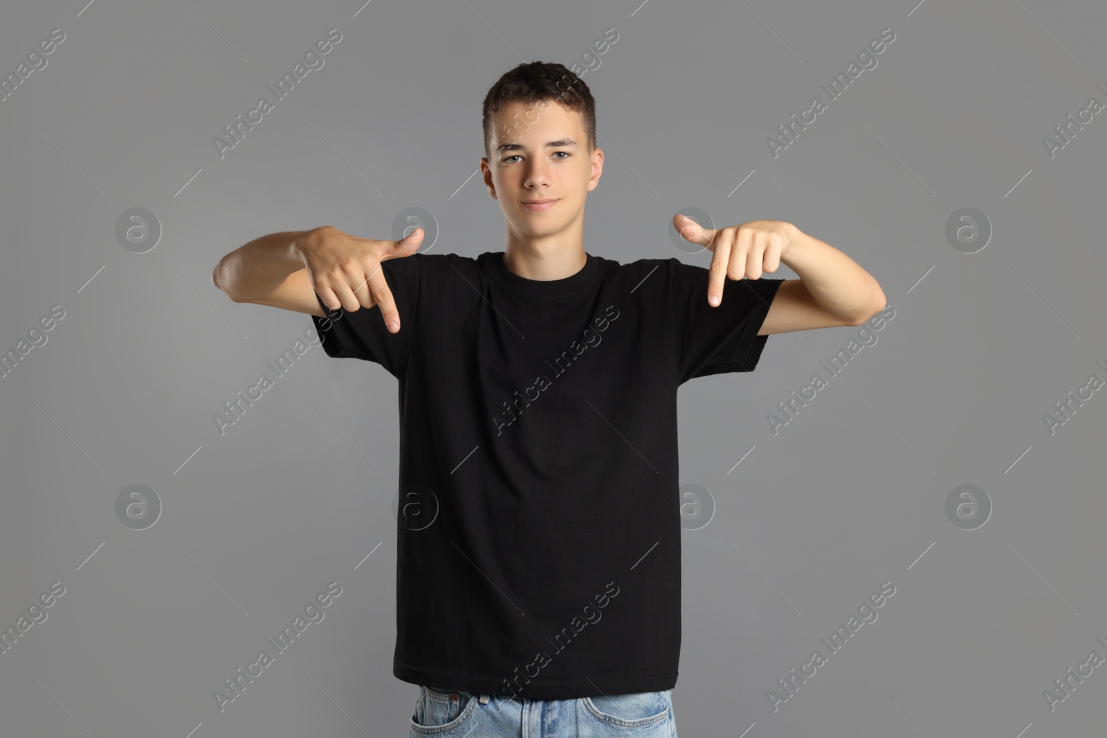 Photo of Teenage boy wearing black t-shirt on grey background