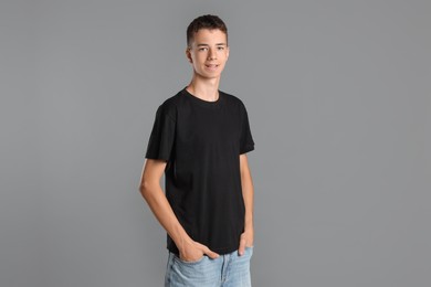 Photo of Teenage boy wearing black t-shirt on grey background