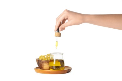 Photo of Woman dripping tincture from pipette into glass jar on white background, closeup