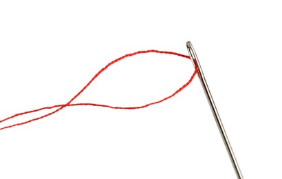 Photo of Sewing needle with red thread isolated on white