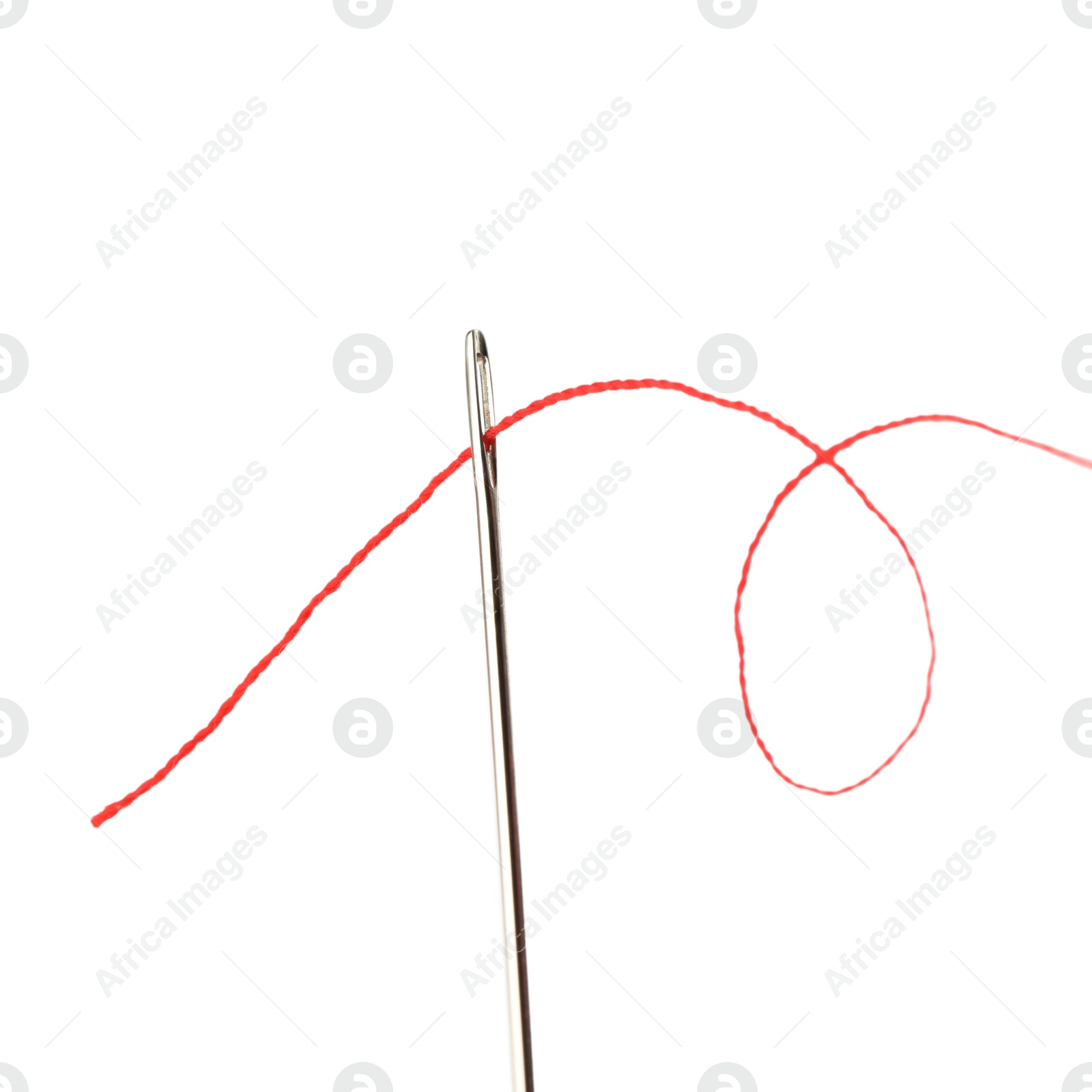 Photo of Sewing needle with red thread isolated on white