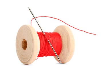 Photo of Spool of red sewing thread with needle isolated on white