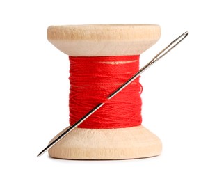 Photo of Spool of red sewing thread with needle isolated on white