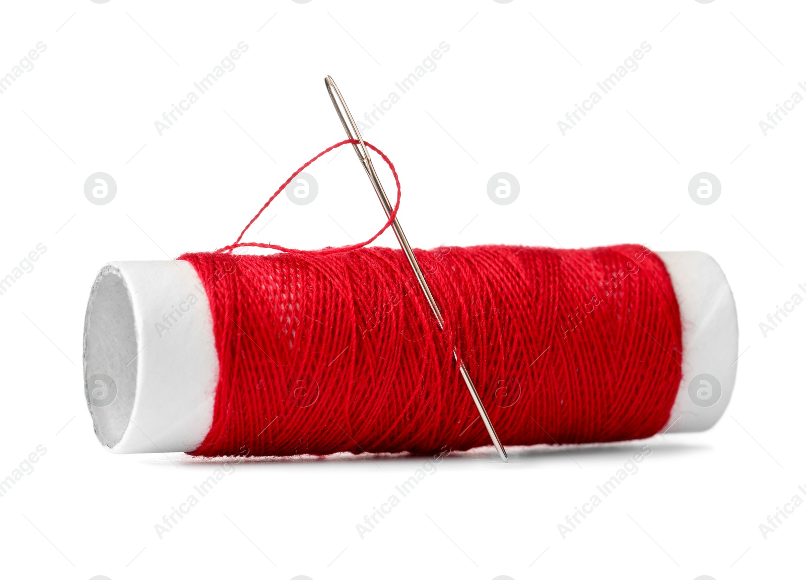 Photo of Spool of red sewing thread with needle isolated on white