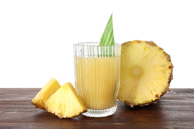 Photo of Glass with pineapple juice and pieces of fresh fruit on wooden table against white background