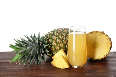 Photo of Glass with pineapple juice and fresh pineapples on wooden table against white background