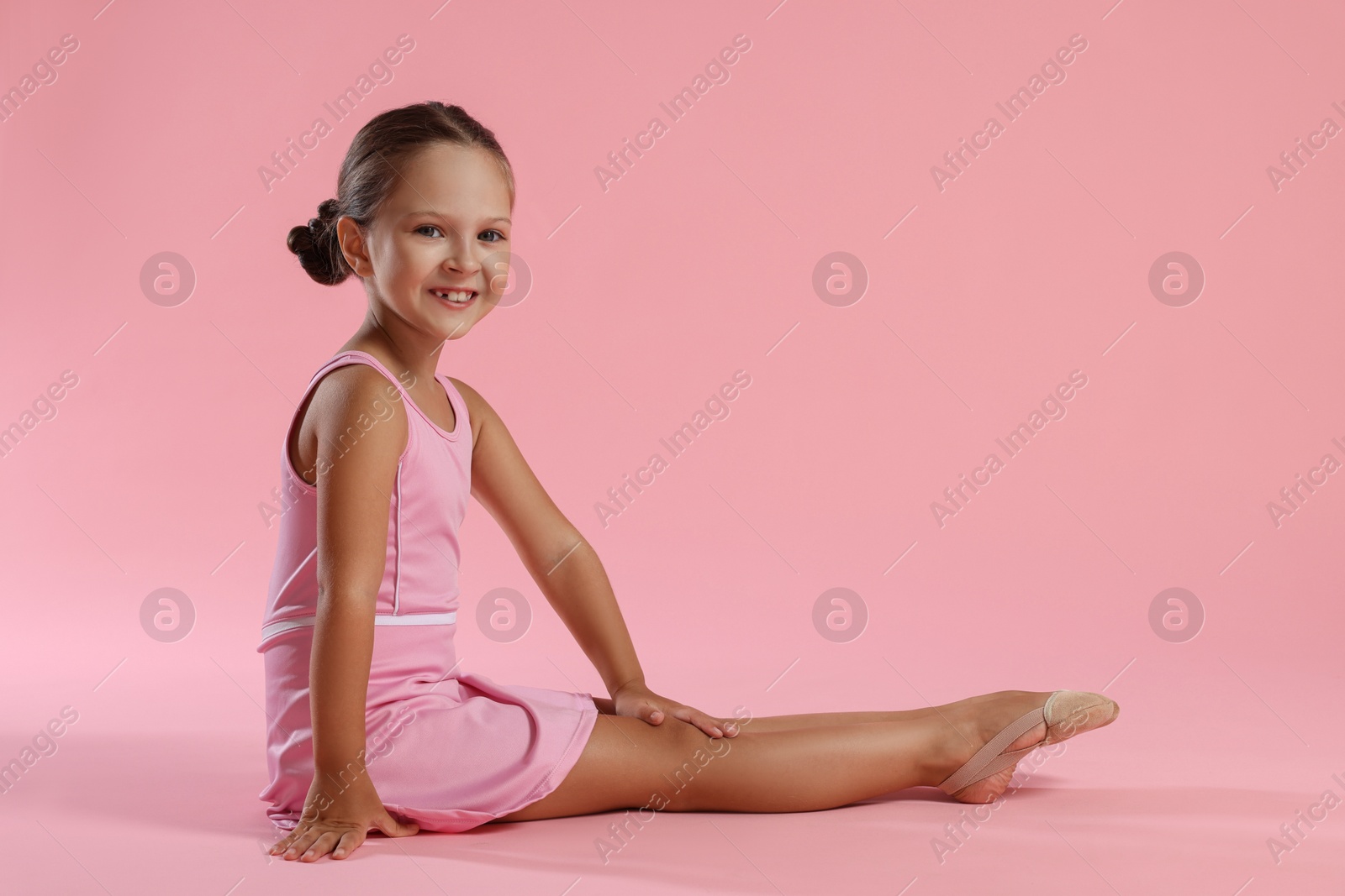 Photo of Portrait of little ballerina on pink background