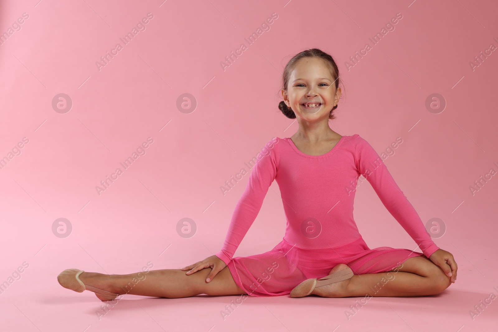 Photo of Portrait of little ballerina on pink background