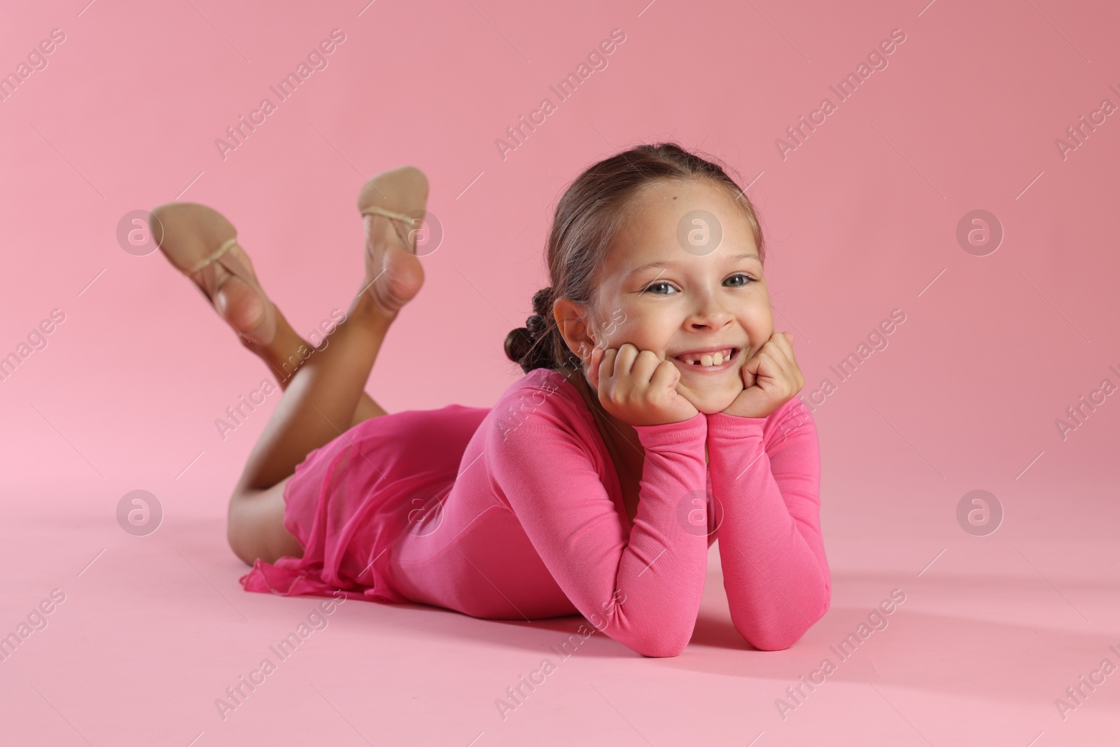 Photo of Portrait of little ballerina on pink background