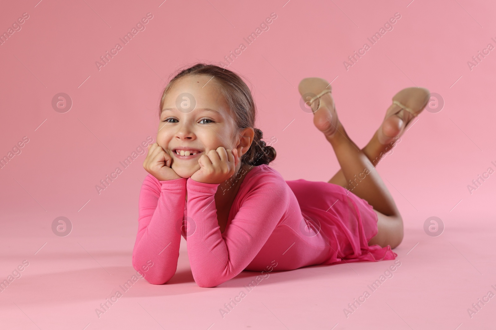 Photo of Portrait of little ballerina on pink background