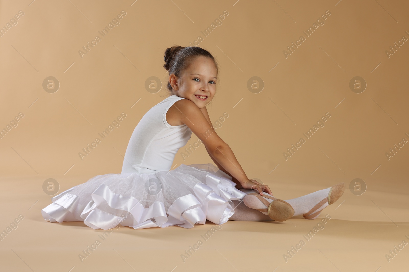 Photo of Portrait of little ballerina on beige background