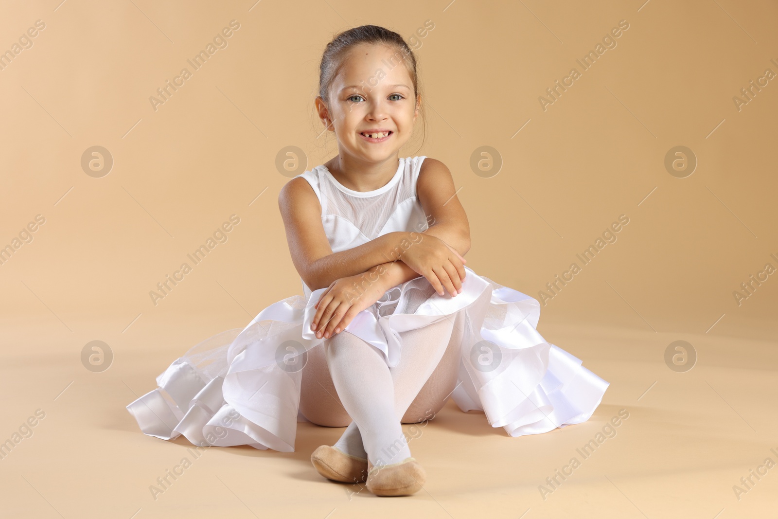 Photo of Portrait of little ballerina on beige background