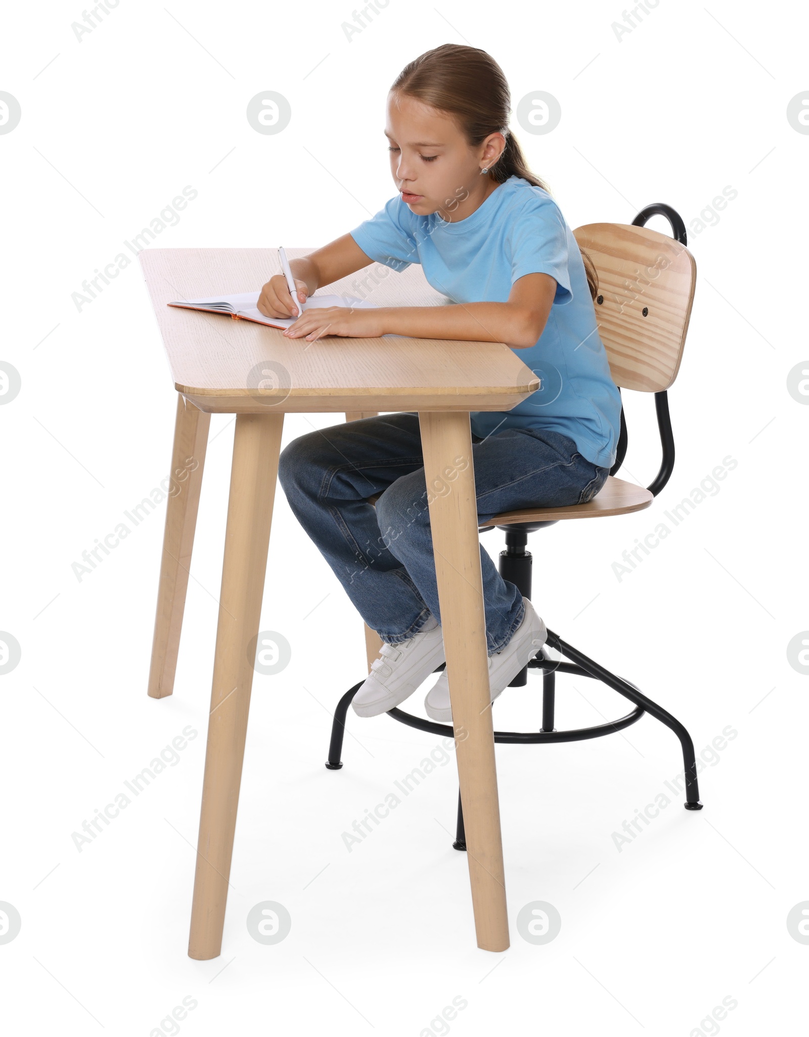 Photo of Girl with incorrect posture and notebook sitting at wooden desk on white background