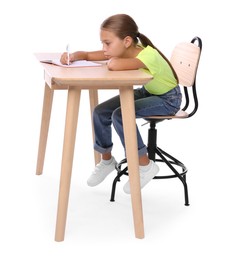 Girl with incorrect posture and notebook sitting at wooden desk on white background