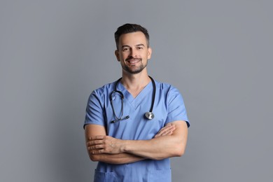 Photo of Smiling nurse with stethoscope on grey background