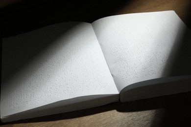 Book with Braille text on wooden table. Education and leisure for blind people