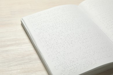 Photo of Book with Braille text on wooden table. Education and leisure for blind people