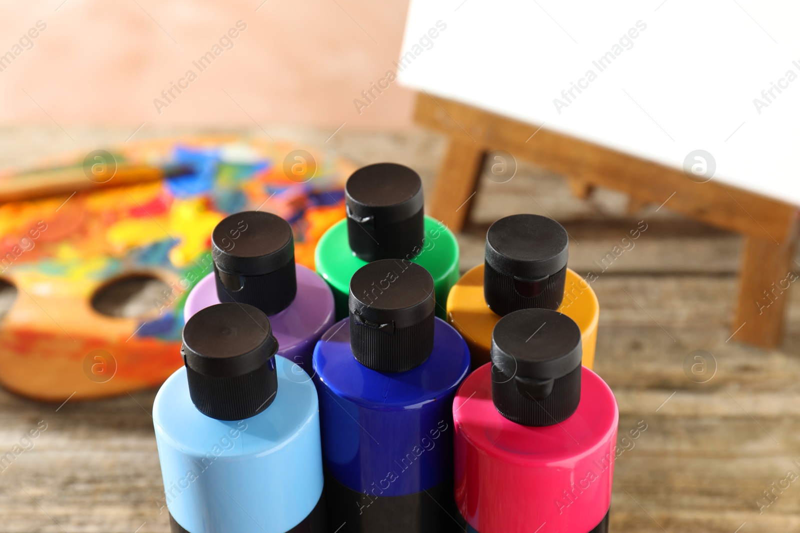 Photo of Acrylic paints of different colors in bottles on table, closeup