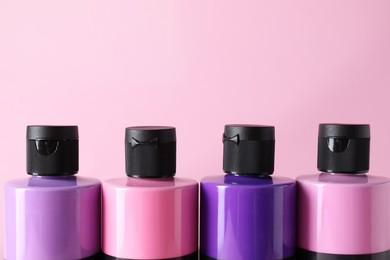 Photo of Acrylic paints of different colors on pink background, closeup