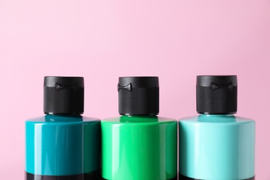 Photo of Acrylic paints of different colors on pink background, closeup