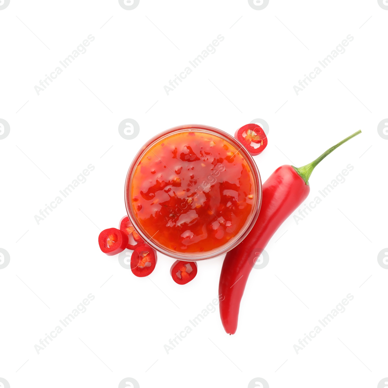 Photo of Hot chili sauce in bowl and pepper isolated on white, top view