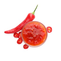 Photo of Hot chili sauce in bowl and pepper isolated on white, top view