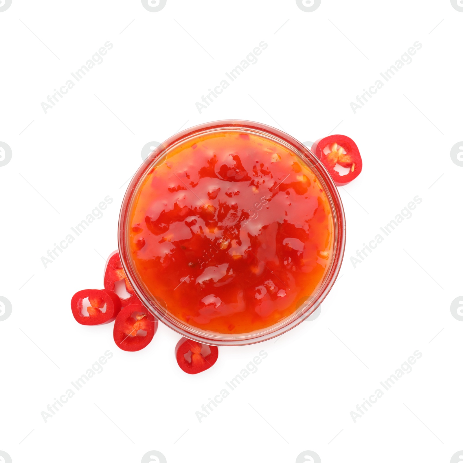 Photo of Hot chili sauce in bowl and pepper isolated on white, top view