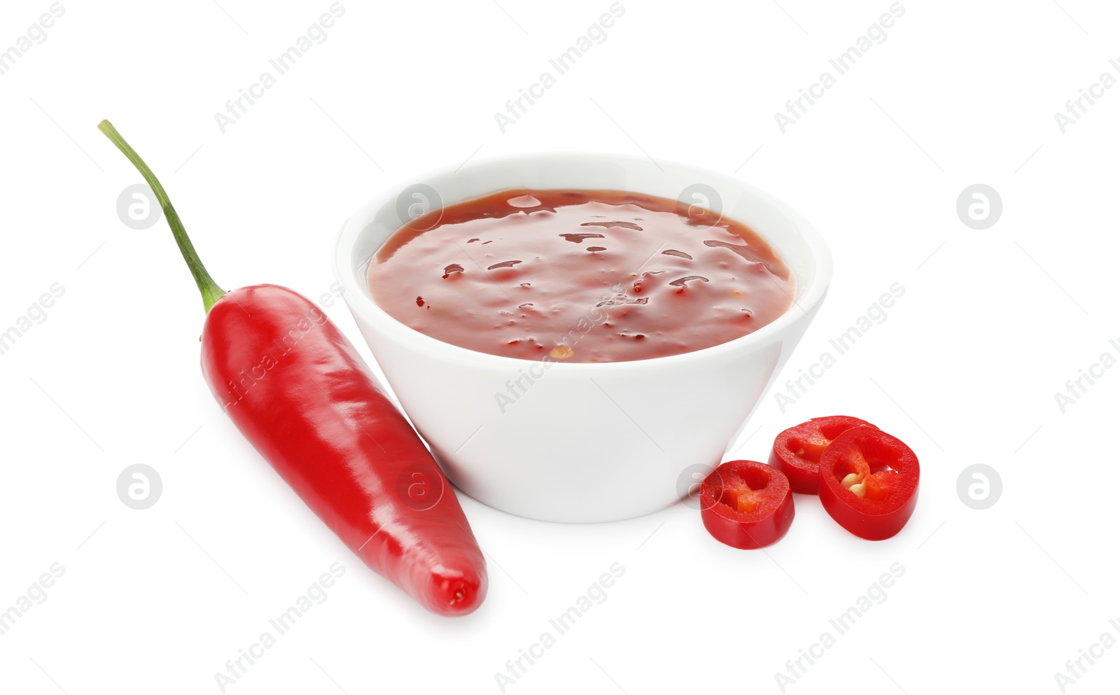 Photo of Hot chili sauce in bowl and pepper isolated on white