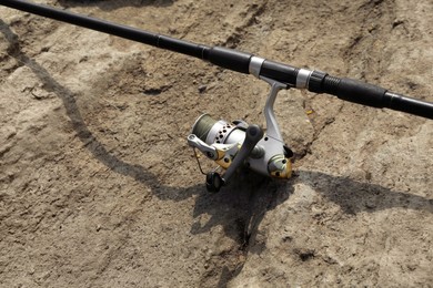 Photo of One fishing rod on ground outdoors, closeup