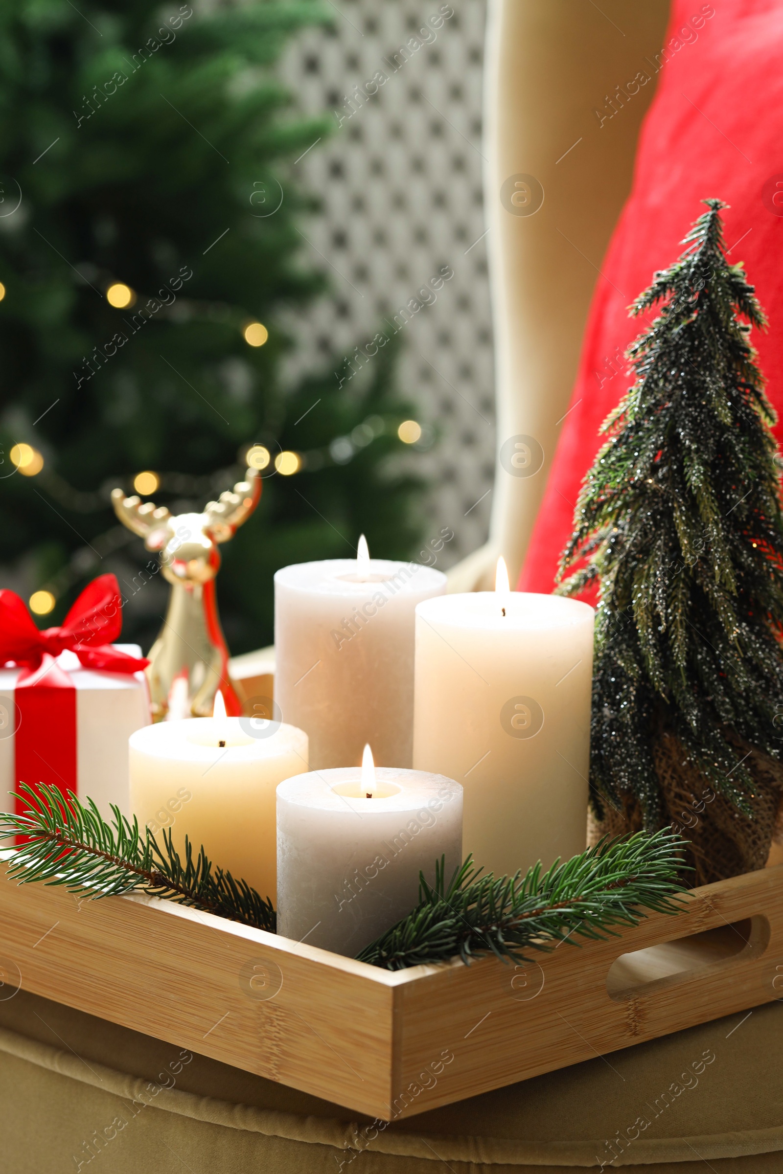 Photo of Tray with burning candles and Christmas decor on blurred background