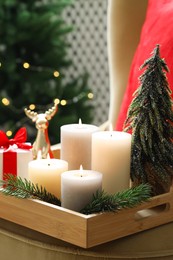 Photo of Tray with burning candles and Christmas decor on blurred background