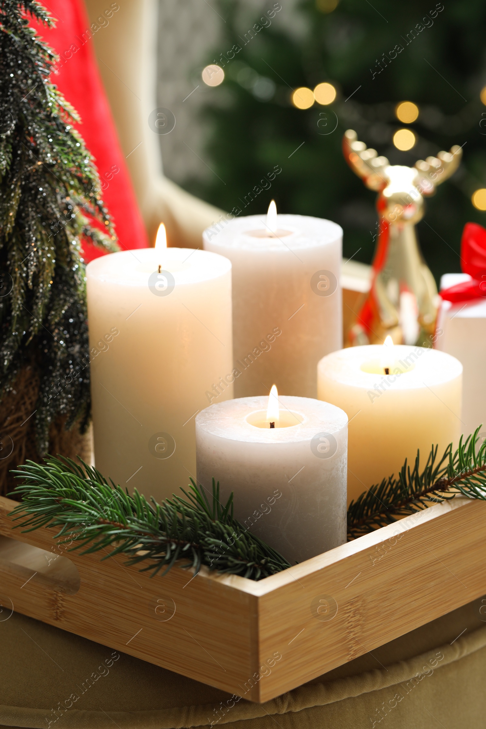 Photo of Tray with burning candles and Christmas decor on blurred background