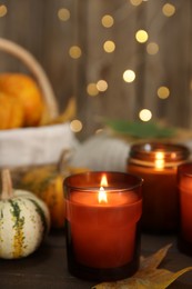 Photo of Burning candles and autumn decor on wooden table