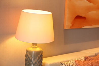 Photo of Stylish lamp near light wall in room, closeup