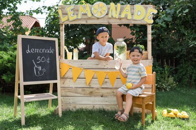 Photo of Cute boys near lemonade stand in park