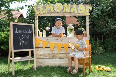 Photo of Cute boys near lemonade stand in park