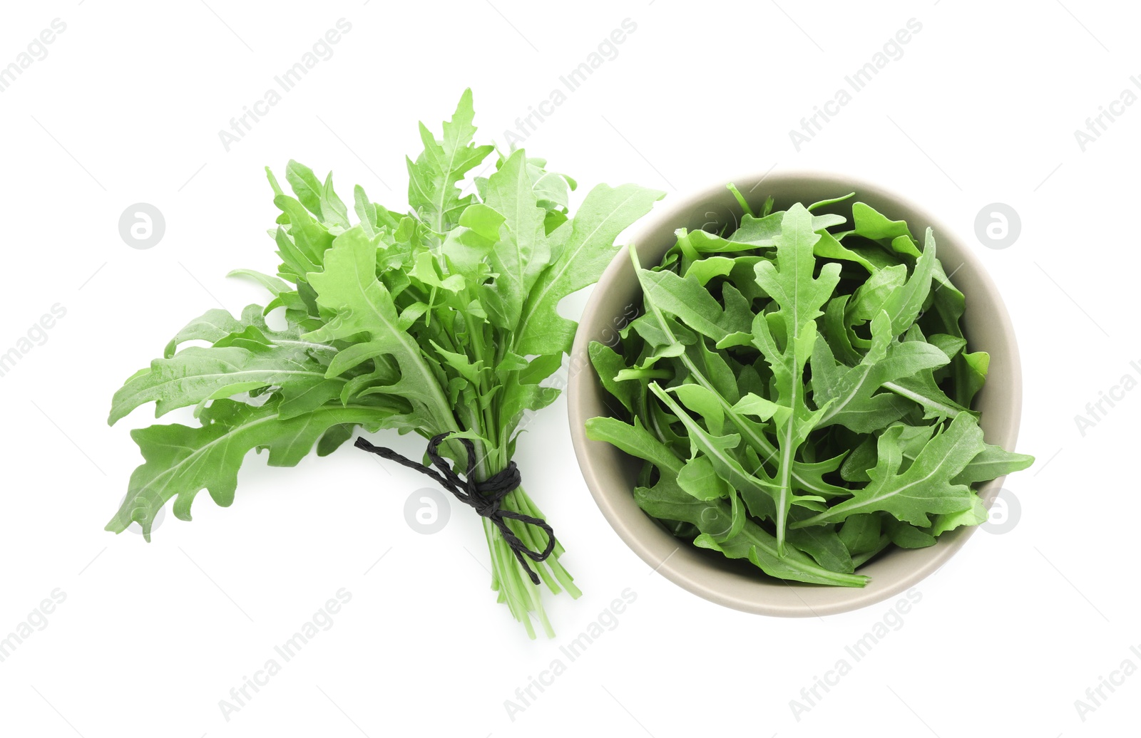 Photo of Bunch of fresh arugula leaves and bowl isolated on white, top view