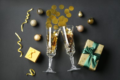 Photo of Flat lay composition with confetti and glasses on grey background. Christmas decor