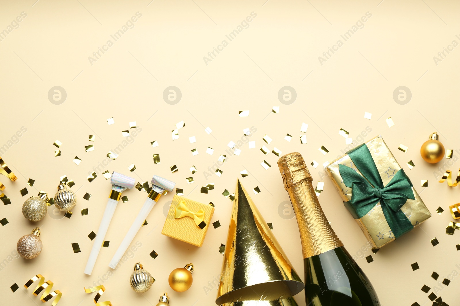 Photo of Flat lay composition with confetti and bottle of sparkling wine on beige background, space for text. Christmas decor