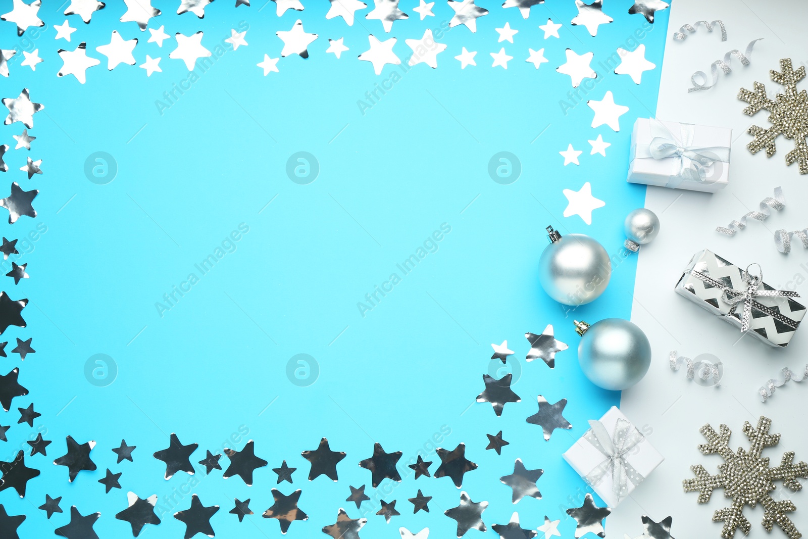 Photo of Flat lay composition with confetti and gift boxes on light blue background, space for text. Christmas decor