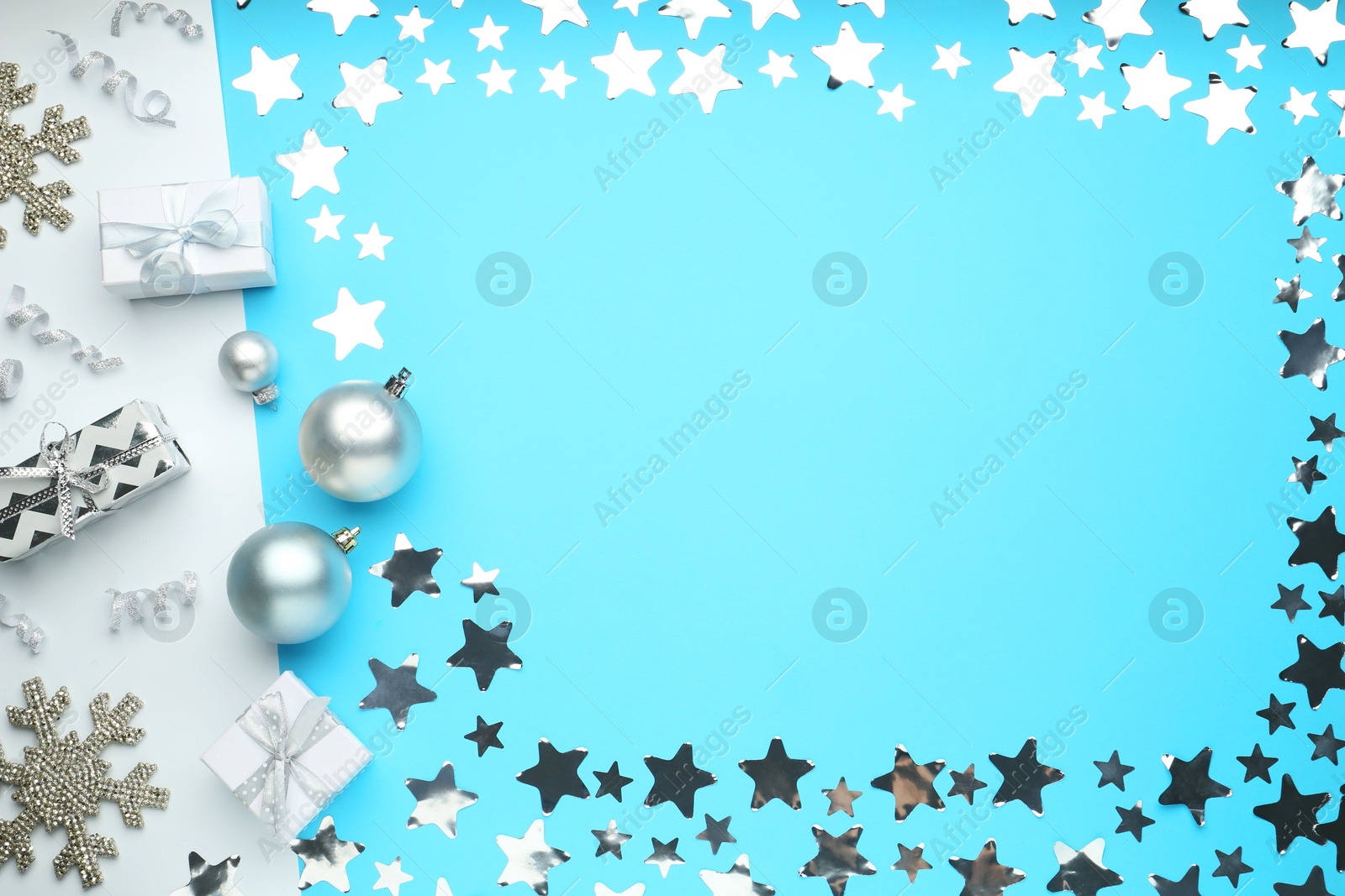 Photo of Flat lay composition with confetti and gift boxes on light blue background, space for text. Christmas decor