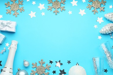 Photo of Flat lay composition with confetti and other Christmas decor on light blue background, space for text