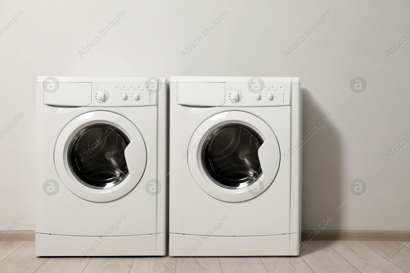 Image of Two washing machines near light grey wall