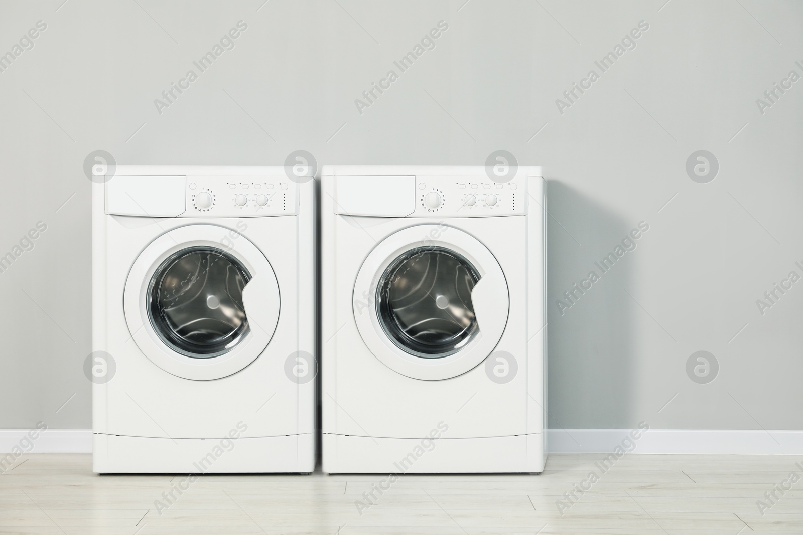 Image of Two washing machines near light grey wall