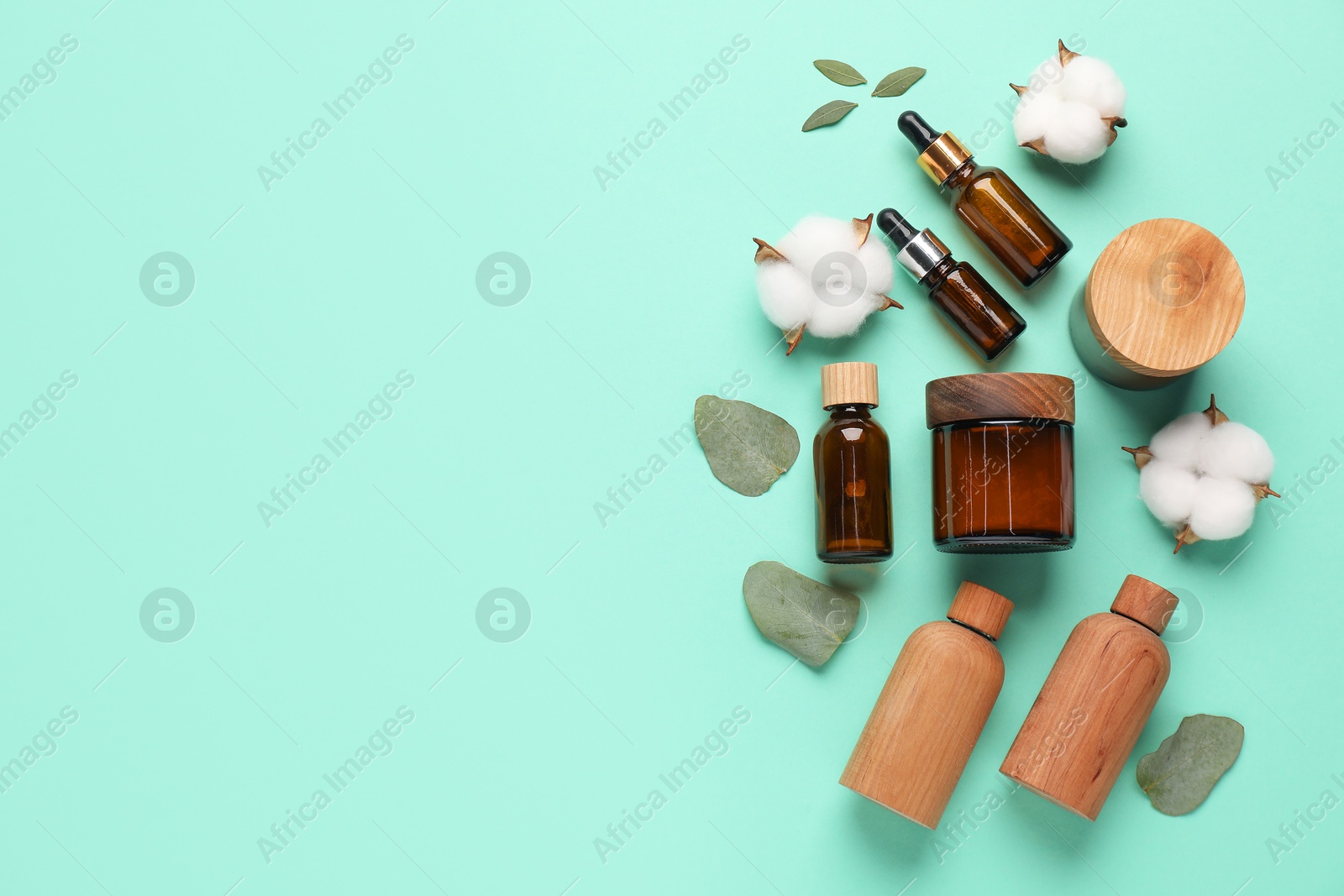 Photo of Different cosmetic products, leaves and cotton flowers on turquoise background, flat lay. Space for text